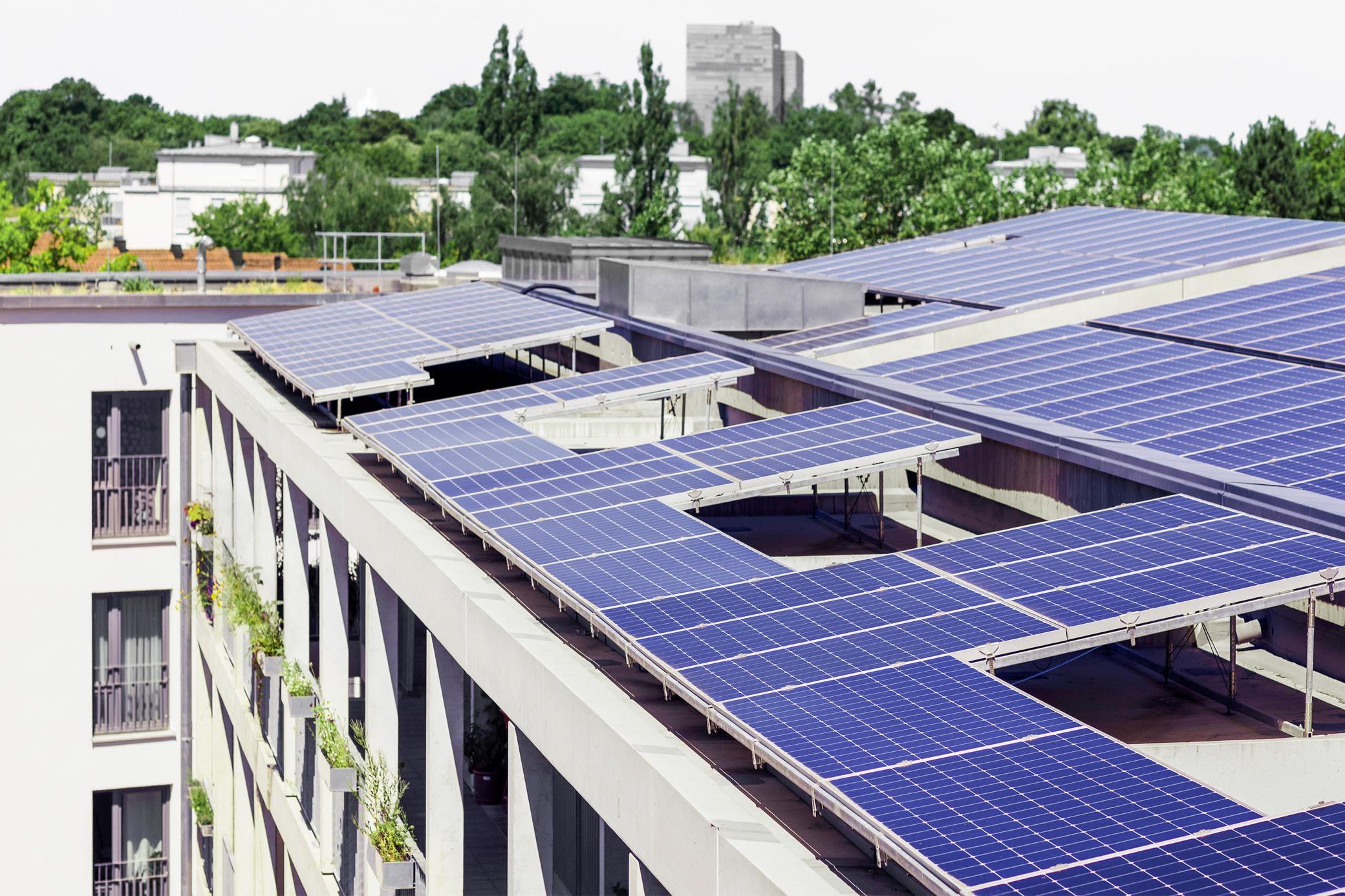 Solarstrom teilen im Mehrfamilienhaus - Z.B. mit Mieterstrom Blaue Solarmodule auf dem Dach eines Mehrfamilienhauses in der Stadt