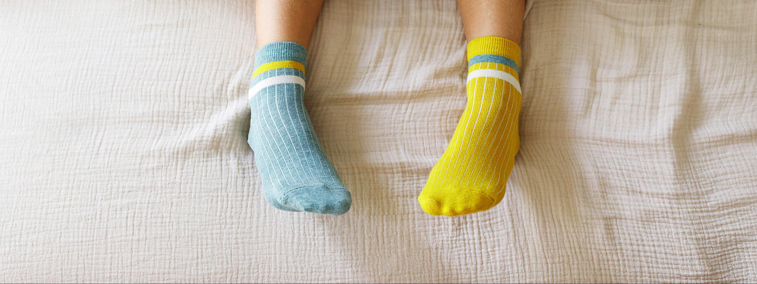 Reduzierte Umlagen für deine Wärmepumpe? So geht’s. Füße in warmen Stricksocken liegen auf einer Bettdecke