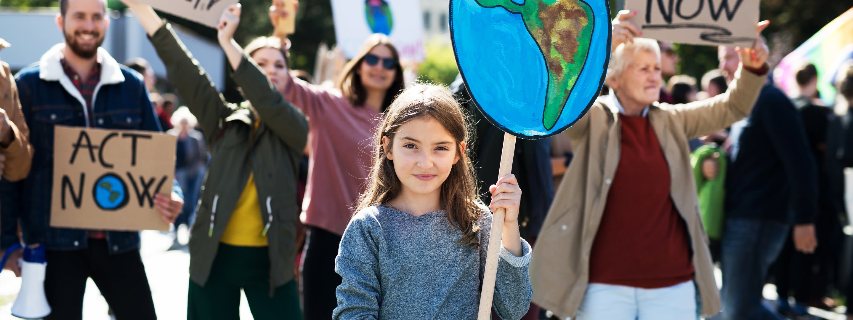 Zu früh am Limit - handeln am Earth Overshoot Day Mädchen hält Abbildung der Erde auf einer Klima-Demo in die Luft