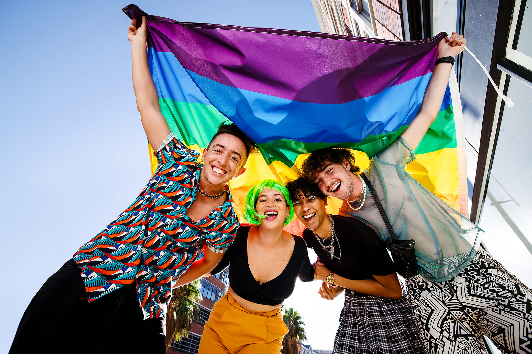 Bei Yello sind wir bunt - so wie deine Stadt Freunde halten zusammen eine Regenbogenfahne hoch