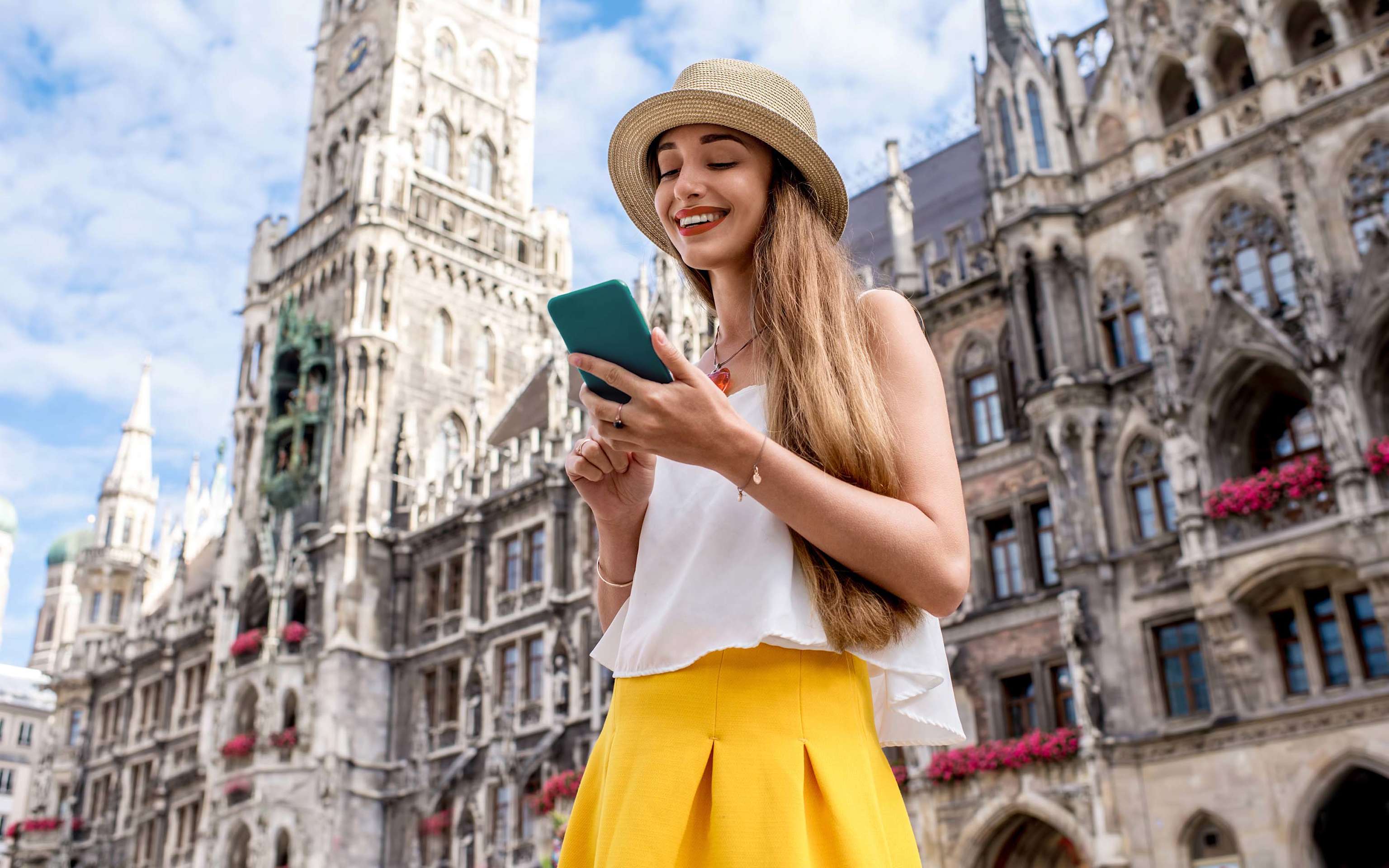 Frau schaut auf ihr Handy am Marienplatz in München Frau schaut auf ihr Handy am Marienplatz in München