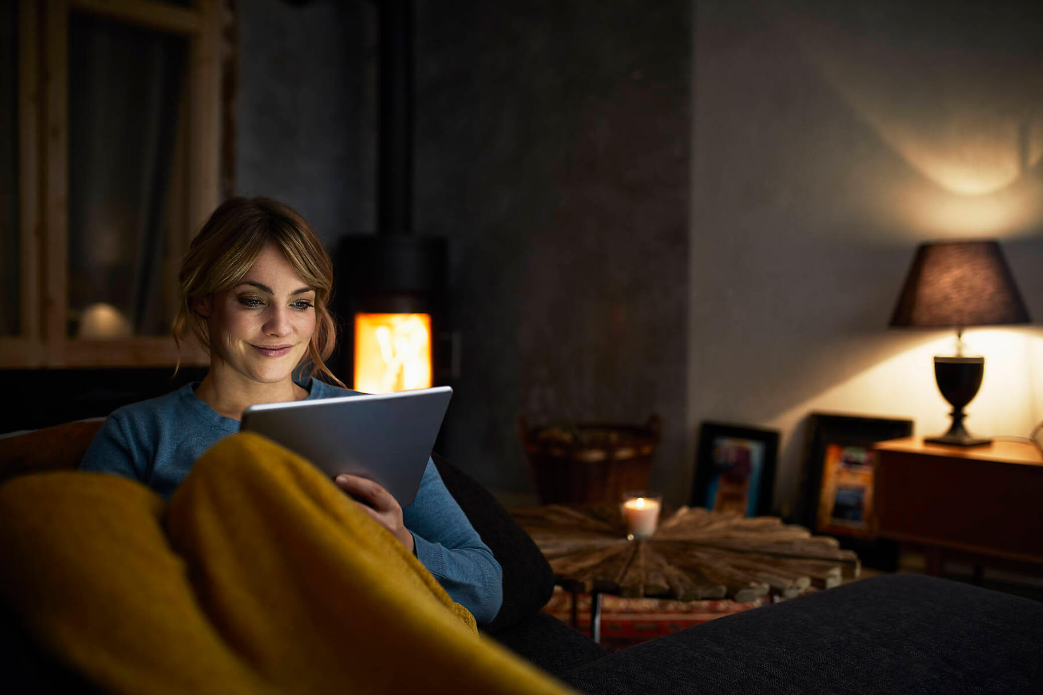 Gute Energie die bis in den Abend reicht Frau schaut Abends bei gedimmten Licht aufs Tablet
